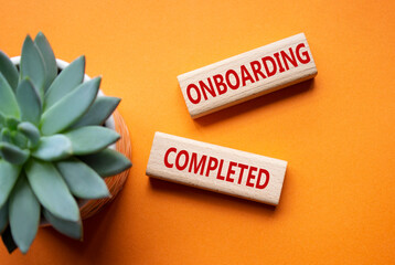 Onboarding Completed symbol. Concept word Onboarding Completed on wooden blocks. Beautiful orange...