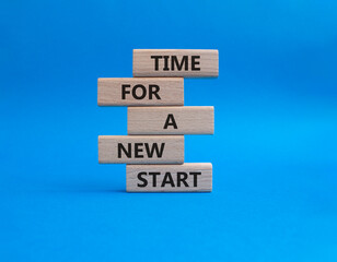 Time for a new start symbol. Wooden blocks with words Time for a new start. Beautiful blue...