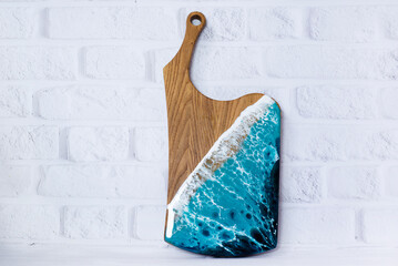 Kitchen board made of wood. Epoxy resin with the effect of the sea. On the background