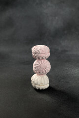 white and pink marshmallows on a black background