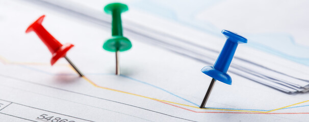 Marking financial chart by pins.Share listing and checking financial chart. Concept of banking, financial report and financial audit.