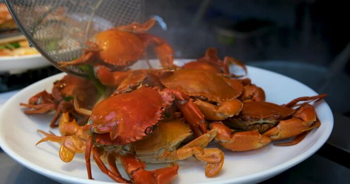 Close-up boiled red crabs, avocado, laurel, wine glasses Steamed crab in a dish. Boiled crab fresh served with spicy sauce on white background. Thai food style,Top view. 