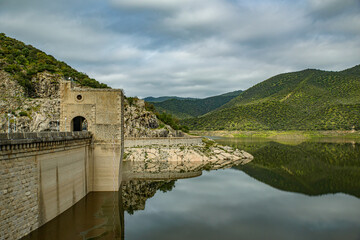 Dam reflection on a calm reservoir.