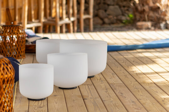 Crystal singing bowls for sound therapy on wooden floor