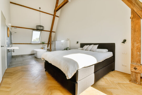 Modern Bedroom with Bathtub and Wooden Beams