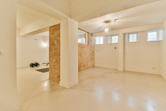 Spacious basement room with exposed brick column