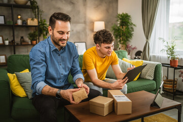 Two caucasian men pack and check package together at home