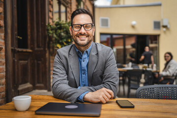 Portrait of adult cheerful man sit in cafe restaurant and smile