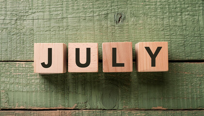 Fototapeta premium Wooden blocks with word JULY on green wood background. Summer time. Flat lay. Close-up.