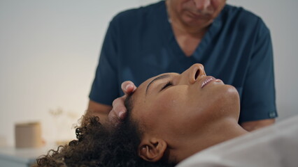 Closeup patient lying physiotherapy in hospital ward. Grey hair man osteopath