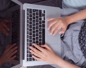 close-up of a woman's hands typing on her laptop