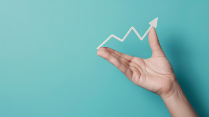 Conceptual image of a hand holding a white paper arrow indicating growth on a vibrant blue backdrop