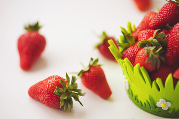 Fresh ripe organic strawberry in green cute basket. Fresh juicy strawberries with leaves. Strawberry on white background. Healthy food concept. Fresh organic berries.