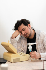 Person with respiratory problems in the living room trying to used a old nebulizer and get confused