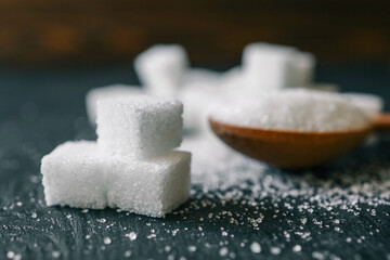 White crystalline sugar cubes on a wooden spoon