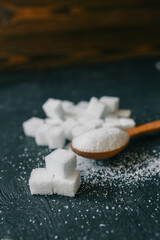 White crystalline sugar cubes on a wooden spoon