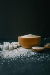 White crystalline sugar cubes on a wooden spoon