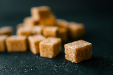Cane sugar cubes on black background