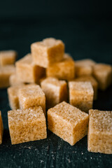 Cane sugar cubes on black background
