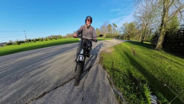 Senior citizen man riding e-bike in the country in Springtime.
