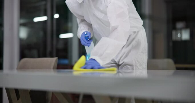 Spray, disinfectant and person in ppe in lab for germs, virus exposure or prevent infection. Protection, cleaning and health worker with disposable suit for decontamination, chemical or medical waste