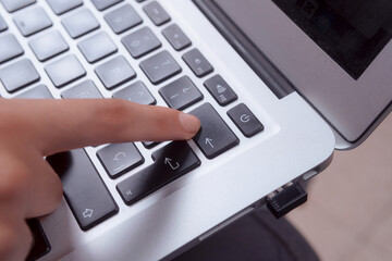 close-up of a woman's hands typing on her laptop