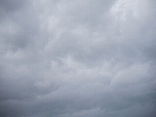 A cloudy sky with no sun. The sky is grey and the clouds are white. Nature background for design