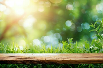 Empty wooden table with grass and plants in the foreground, blurred green bokeh background. Outdoor nature scene with copy space. Spring and summer concept for design and print