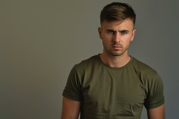 Obraz premium A man wearing a green t-shirt stands posing for the camera, simple and casual
