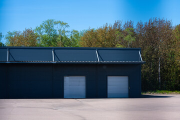 Grey warehouse with two garage ports.