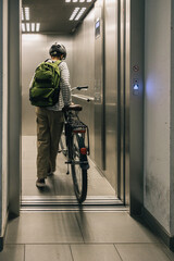 Girl riding her bicycle out of the elevator, morning routine