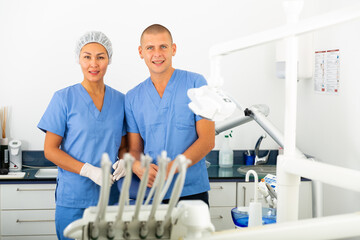 Portrait of successful dentist and his nurse assistant in a clinic office