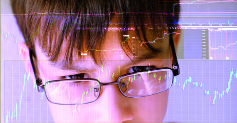 Intelligent 12-year-old child, boy wearing glasses intently studies stock market charts on computer screen, showcasing potential young financial traders, future of finance, financial literacy