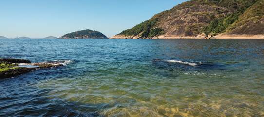 beach sand stone sea wave water vegetation coconut palm tree wall texture blue sky horizon...