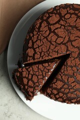 Delicious chocolate truffle cake on grey table, top view