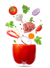 Stuffed pepper recipe. Fresh ingredients falling into bell pepper on white background