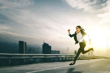 Businesswoman looks hurry while running fast on the road with cityscape background