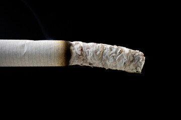 Close-up shot of smoking cigarette end on black background