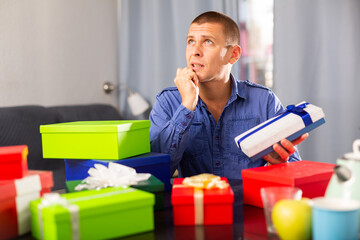 Pensive man decide who to give boxes of gifts for Valentines Day or international womens day