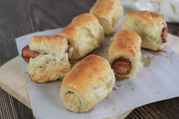 Sausage rolls on wooden table. Puff pastry eat with coffee or tea. Traditional British food concept. Food photography