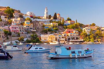Panoramic view of colorful houses and boats in the harbor of Symi Island, Greece, at sunset