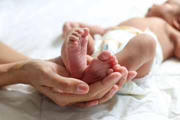 Baby feet in mother hands. Beautiful conceptual image of maternity.
