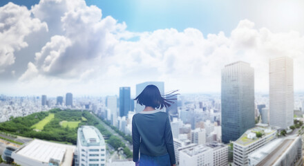 日本の街・都市・朝日を受けたオフィスビル群を前に佇み風を受けて髪をなびかせる会社員の女性の出勤　就職・ビジネス・はじまり・決意・目標・挑戦のイメージ