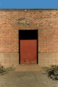Puerta roja en edificio de fachada de ladrillo naranja 