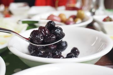 closeup of spoon pick black olives 