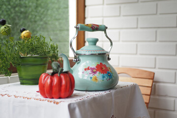 A vintage teapot, pepper shaker, herb pot, and a lace tablecloth in a cozy, retrostyle kitchen