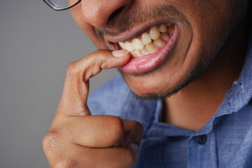  young men biting his nails at home,