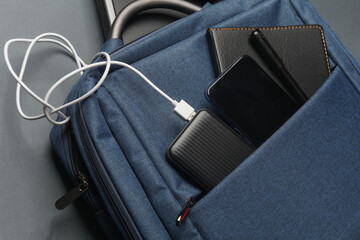 Laptop with Modern gadgets and accessories for work and study in Backpack on dark gray background. Top view. Flat lay