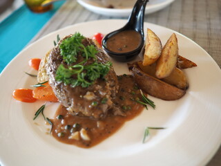 A delicious dinner plate with grilled beef steak and colorful vegetables cooked in a savory sauce