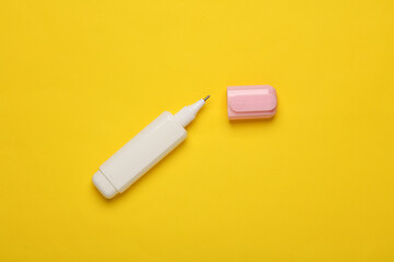 Stationery corrector on yellow background. Top view